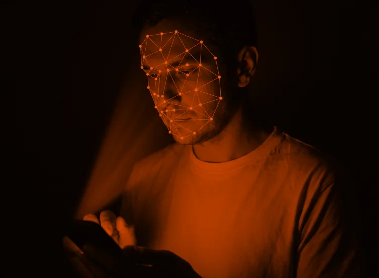 A face-mapping mesh over a person holding a phone.