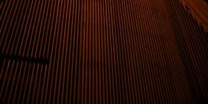 A ribbed dark facade in raking light.